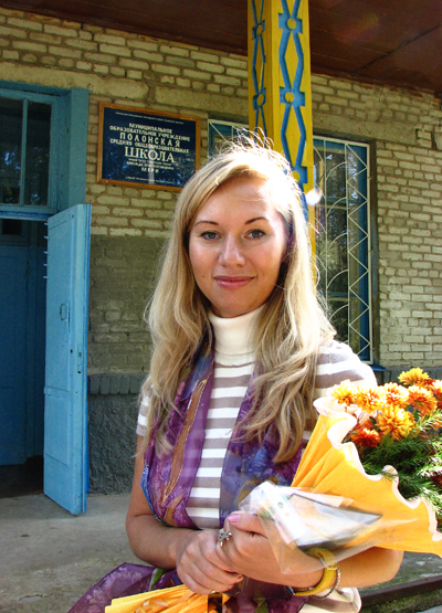 Анастасия Мяльсон на фоне школы, носящей имя её деда